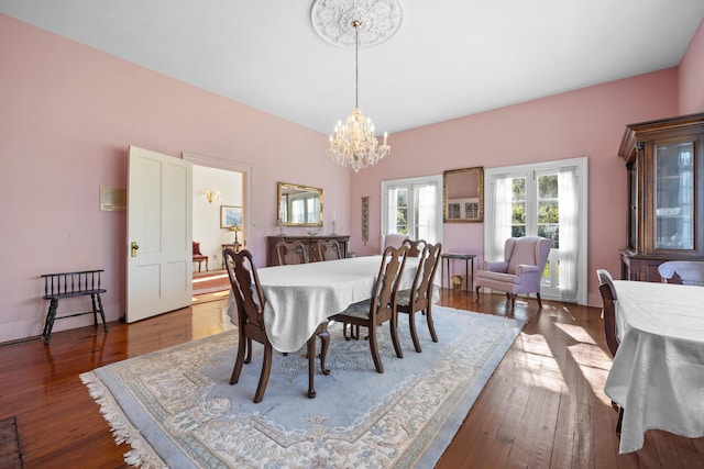 dining room with an inviting chandelier and dark hardwood / wood-style flooring