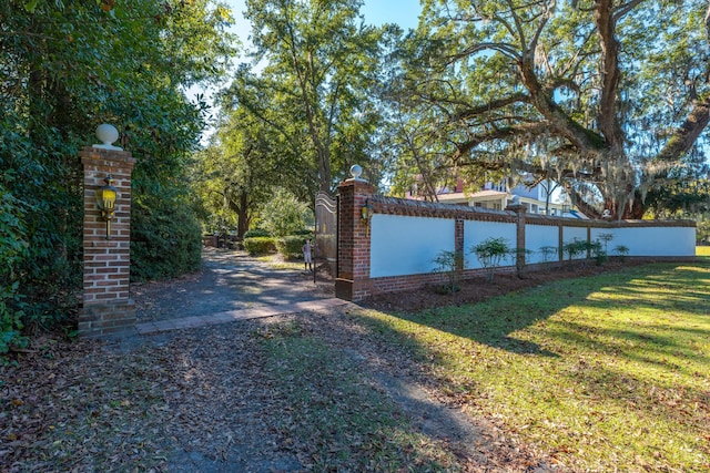 view of gate with a lawn