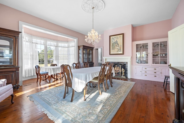 dining area with a notable chandelier and dark hardwood / wood-style floors