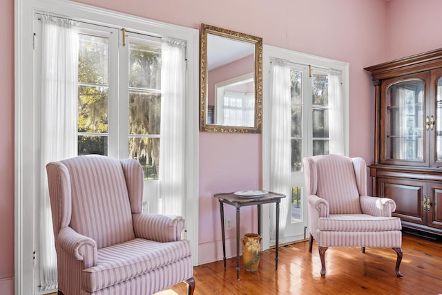 sitting room with a wealth of natural light and wood-type flooring