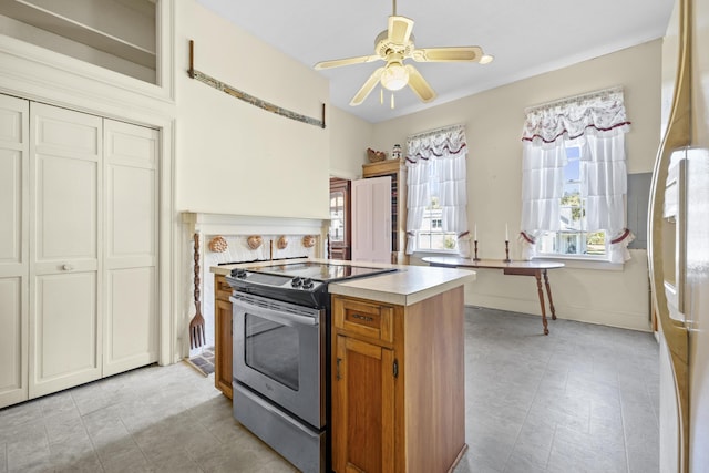 kitchen featuring electric range, ceiling fan, and a center island