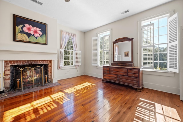 sitting room with a healthy amount of sunlight, a fireplace, and wood-type flooring