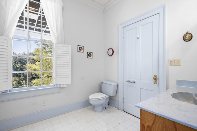 bathroom featuring toilet, ornamental molding, a wealth of natural light, and vanity