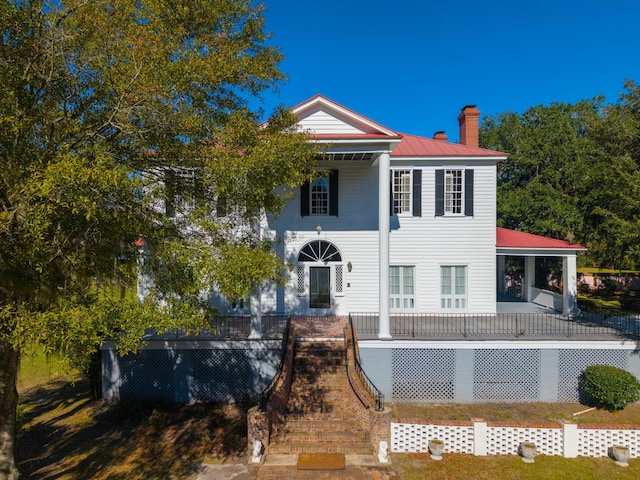 rear view of house featuring covered porch