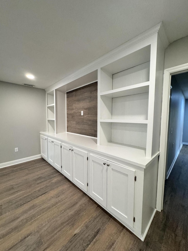 unfurnished living room with dark hardwood / wood-style flooring and built in features