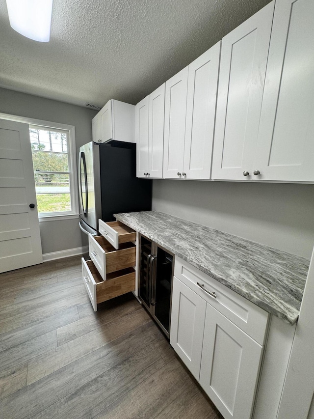 kitchen featuring light stone counters, light hardwood / wood-style flooring, and white cabinets