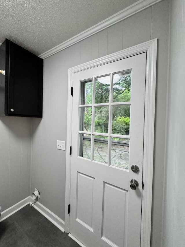 laundry area featuring a textured ceiling, cabinets, and a healthy amount of sunlight