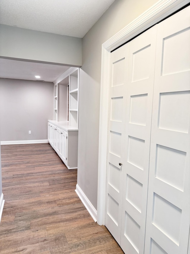 hall with dark hardwood / wood-style flooring and a textured ceiling