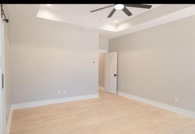 74 Longleaf Dr, Walterboro, SC 29488 - empty room featuring ceiling fan, baseboards, light wood-style flooring, and a raised ceiling