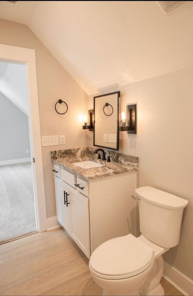 74 Longleaf Dr, Walterboro, SC 29488 - half bathroom with vanity, baseboards, vaulted ceiling, toilet, and wood finished floors
