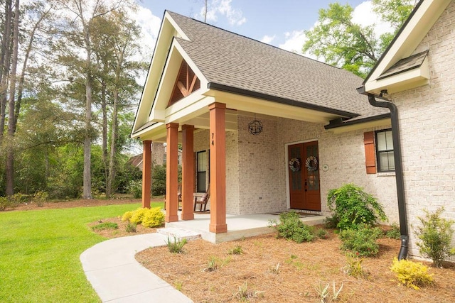 74 Longleaf Dr, Walterboro, SC 29488 - view of exterior entry featuring brick siding, a yard, roof with shingles, and french doors