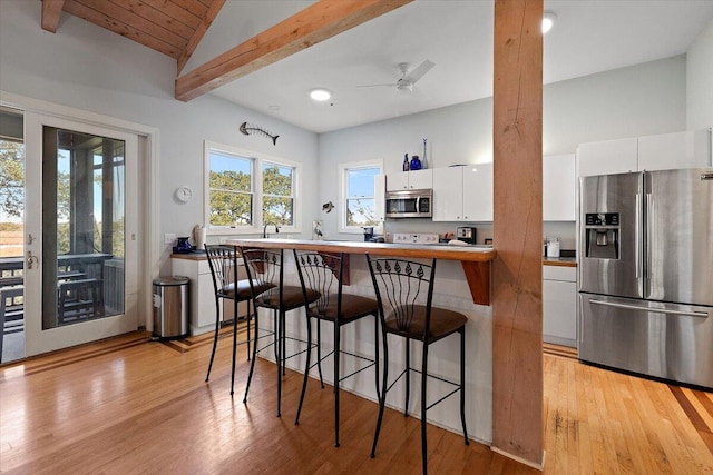 kitchen with white cabinetry, light wood-type flooring, and stainless steel appliances