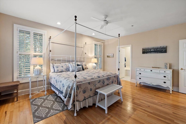 bedroom with ensuite bathroom, ceiling fan, and light wood-type flooring