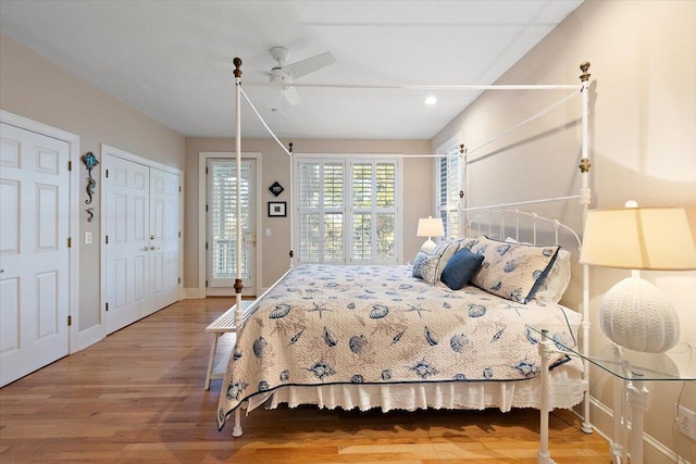 bedroom featuring two closets, ceiling fan, and light wood-type flooring