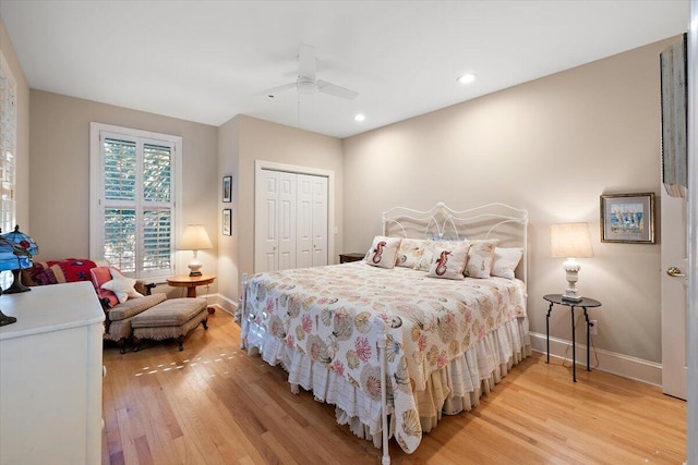 bedroom with a closet, light hardwood / wood-style floors, and ceiling fan