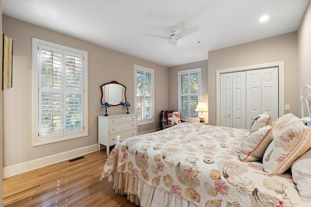 bedroom featuring ceiling fan, light hardwood / wood-style flooring, and a closet