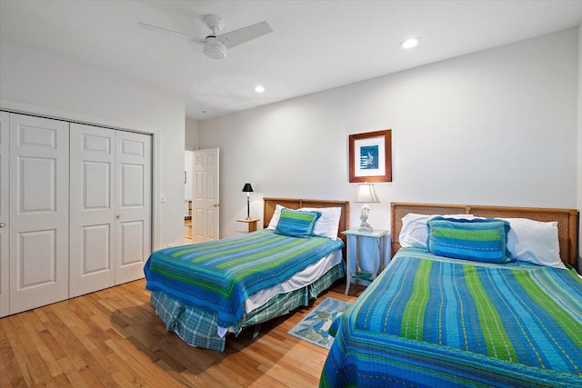 bedroom featuring light hardwood / wood-style flooring, ceiling fan, and a closet