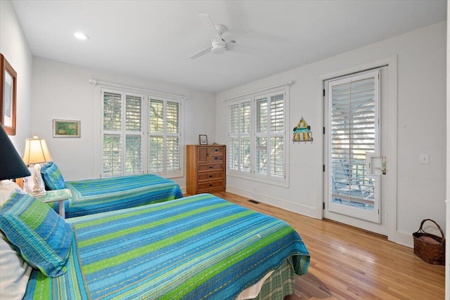 bedroom with light hardwood / wood-style flooring, ceiling fan, access to outside, and multiple windows