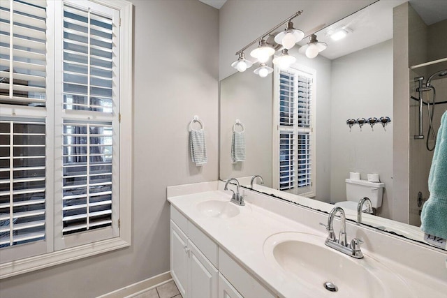 bathroom with toilet, double sink, vanity with extensive cabinet space, and tile flooring