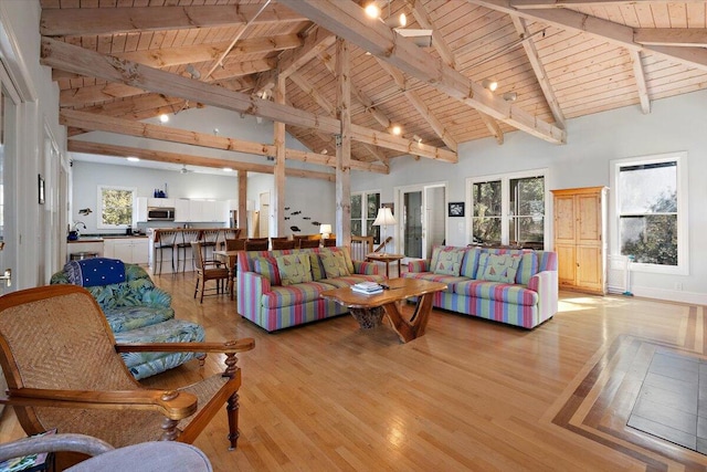 living room with beam ceiling, high vaulted ceiling, light hardwood / wood-style floors, and wooden ceiling