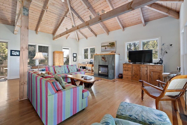 living room with a tiled fireplace, beam ceiling, dark wood-type flooring, and high vaulted ceiling