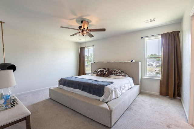 bedroom featuring light colored carpet, baseboards, and ceiling fan