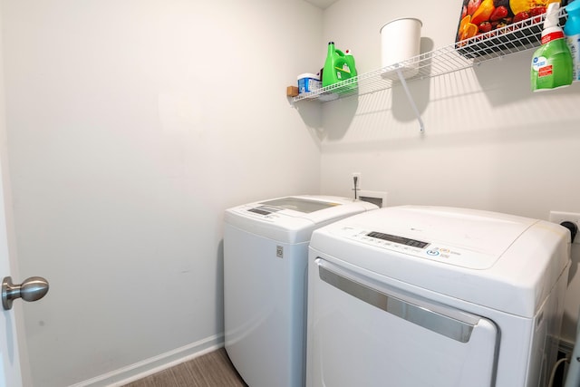 laundry room with independent washer and dryer, wood finished floors, and baseboards
