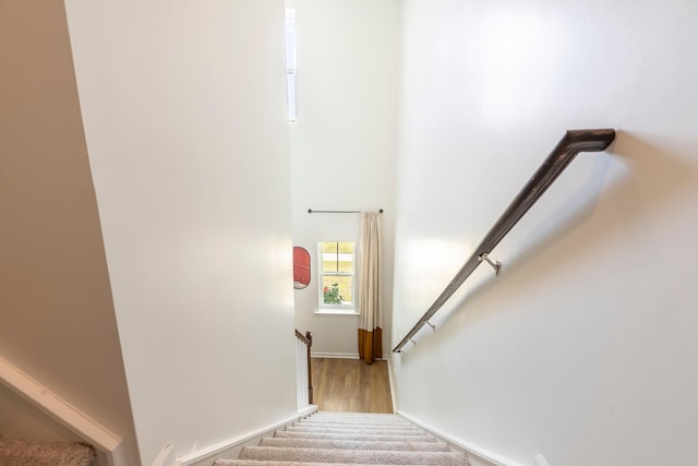 stairway with wood finished floors and baseboards