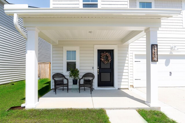entrance to property featuring a garage and covered porch