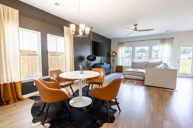 dining space featuring a chandelier, wood-type flooring, and a ceiling fan