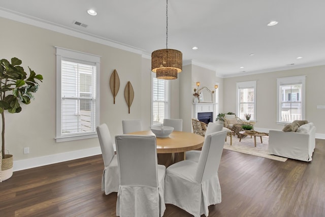 dining room with dark hardwood / wood-style flooring and crown molding