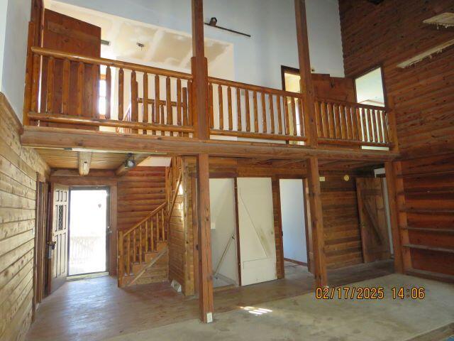 interior space with a high ceiling and log walls