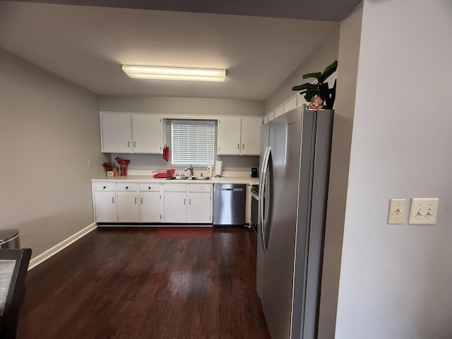 kitchen with stainless steel appliances, light countertops, dark wood-style flooring, a sink, and baseboards