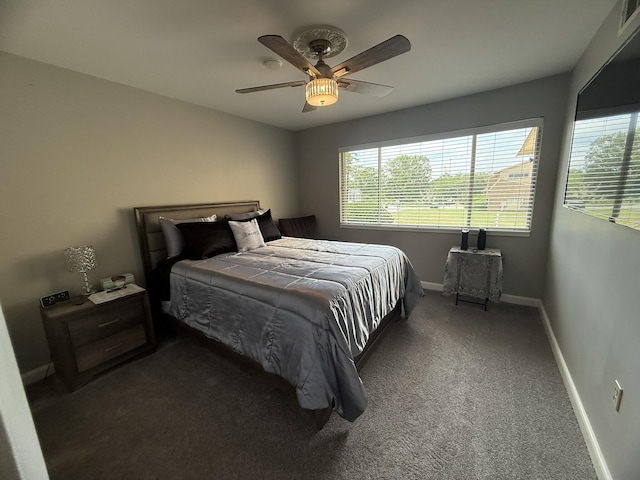 bedroom with baseboards, dark colored carpet, ceiling fan, and multiple windows