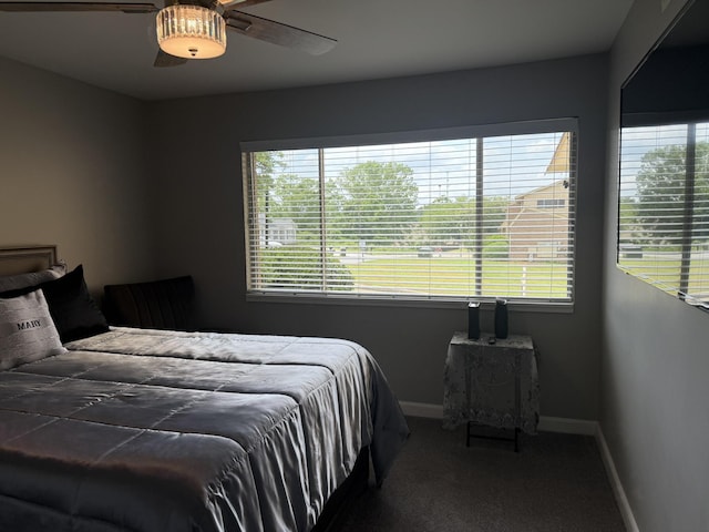 carpeted bedroom featuring multiple windows, ceiling fan, and baseboards