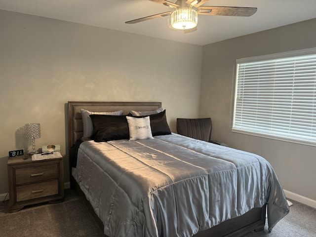 bedroom with dark colored carpet, a ceiling fan, and baseboards