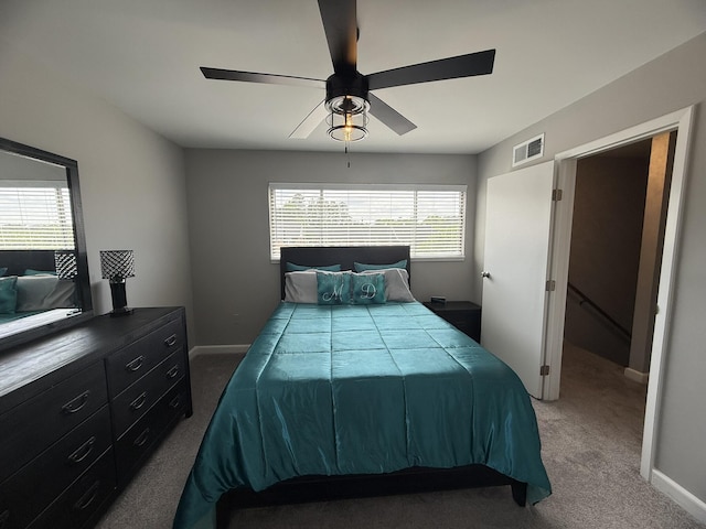 carpeted bedroom with visible vents, a ceiling fan, and baseboards