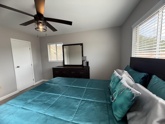 carpeted bedroom featuring a ceiling fan and baseboards