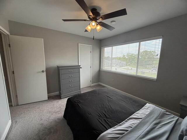 bedroom with a ceiling fan, carpet flooring, and baseboards