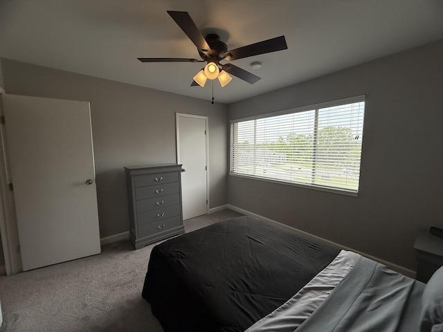 bedroom with light colored carpet, a ceiling fan, and baseboards