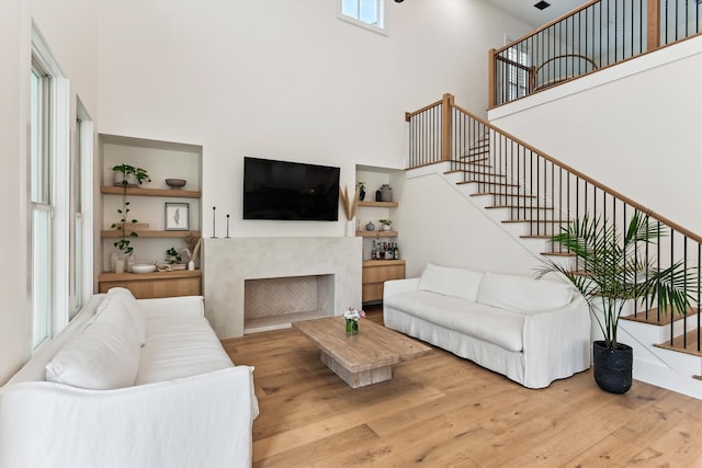 1474 Blue Cascade Dr, Mount Pleasant, SC 29464 - living room with a high ceiling, wood finished floors, stairs, and a fireplace