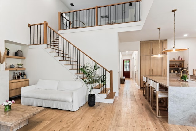 1474 Blue Cascade Dr, Mount Pleasant, SC 29464 - living room with stairway, light wood-style flooring, a high ceiling, and recessed lighting