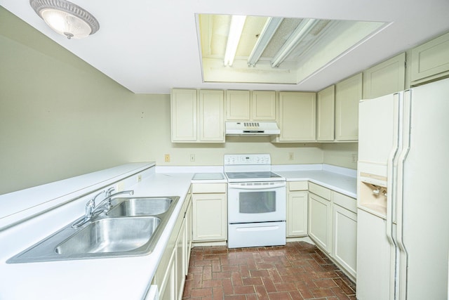 kitchen with cream cabinets, white appliances, and sink