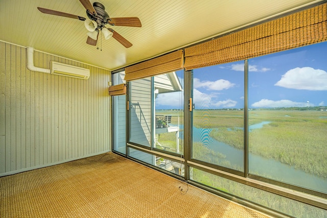 unfurnished sunroom featuring a water view, an AC wall unit, and ceiling fan