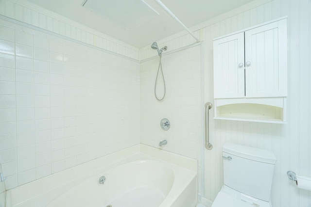 bathroom with toilet and tiled shower / bath