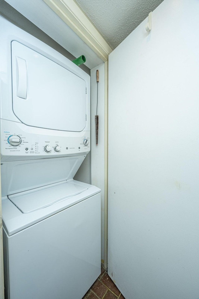 laundry area featuring a textured ceiling and stacked washer and dryer