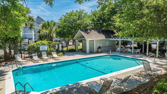 view of pool with a patio area and an outbuilding