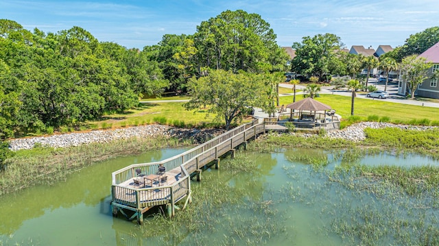 dock area with a gazebo, a yard, and a water view