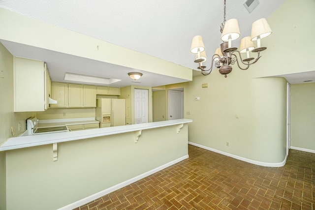 kitchen with stove, white refrigerator with ice dispenser, a kitchen bar, kitchen peninsula, and a chandelier