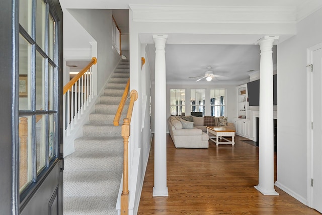 interior space featuring crown molding, decorative columns, dark hardwood / wood-style floors, and ceiling fan